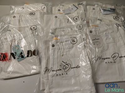 six paires de pantalons blancs sont emballées dans des sacs en plastique sur une table