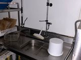 a kitchen with a sink and a metal counter top