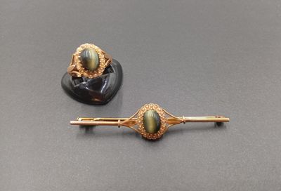 une paire d'épingles à cheveux en or et ornées de pierres vertes