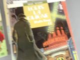 a man in a trench coat and hat walking down the street