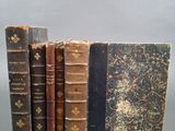 trois vieux livres posés l'un sur l'autre sur une table