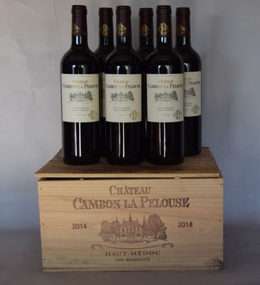 quatre bouteilles de vin rouge dans un coffret en bois posé sur une table
