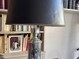a lamp that is sitting on a table in front of a bookshelf