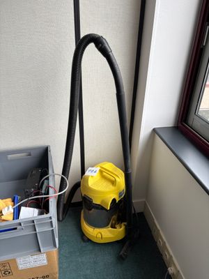 a vacuum and a box on the floor next to a window