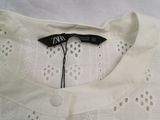 the back of a white shirt with a black tag on it