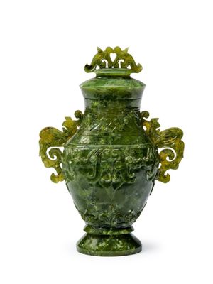 un vase vert posé sur une surface blanche