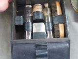 a person holding a brush in a box with other items in it