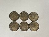 six british coins in a row on a white surface