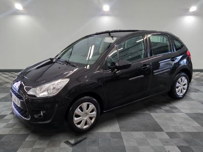 la petite voiture noire est garée sur un sol en damier