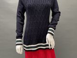 a mannequin wearing a black sweater and red plea skirt