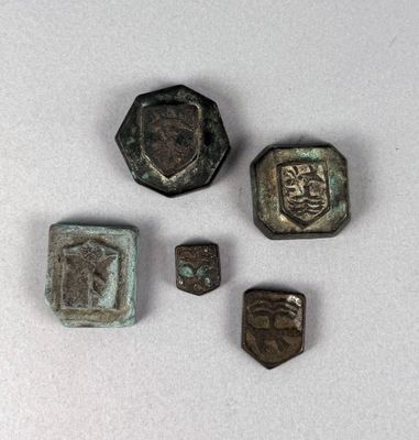 four pieces of metal with a face on them sitting on a white surface