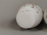two white vases that are sitting side by side