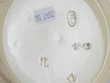 a person holding a white vase with numbers on it