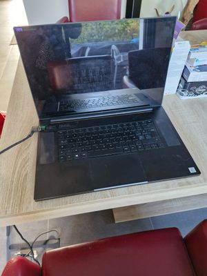 a laptop sitting on a table with a red chair in front of it
