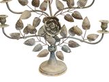 a metal candelab with a rose and leaves on it