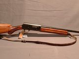un vieux fusil avec un canon en bois et une fronde sur fond blanc