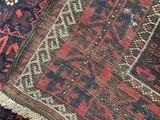 close up of a red and blue oriental rug with a black background