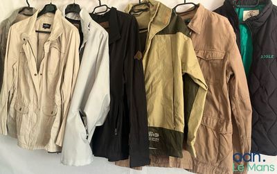 plusieurs vestes suspendues à un porte-manteau dans une pièce