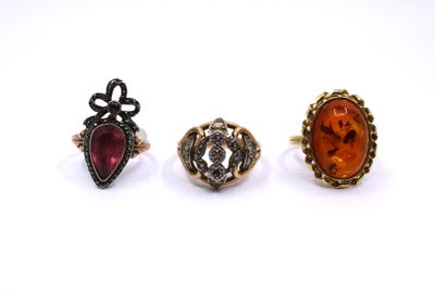 three rings, one with an orange stone and one with a red stone