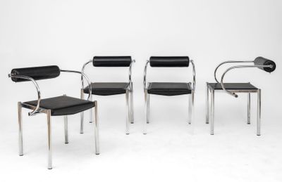 quatre fauteuils en cuir noir aux pieds chromés dans une pièce blanche