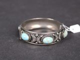 un gros plan d'une bague en argent sertie de pierres de turquoise