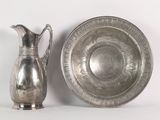 a silver plate and a silver pitcher sitting next to each other