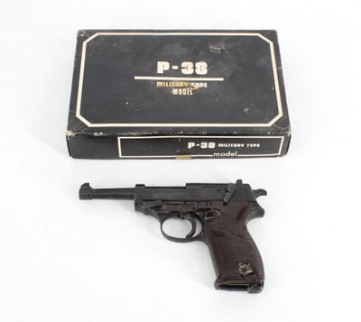a gun and a box on a white surface