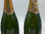 three bottles of champagne are lined up on a table