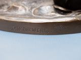 a bronze statue of a bird on a plate