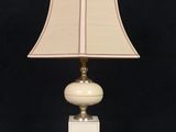 une image représentant une lampe blanche surmontée d'un abat-jour beige