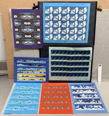 a group of art work displayed on a table in front of a wall