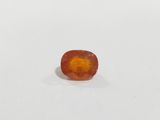 a close up of an orange gemstone on a white surface