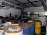 many barrels in the back of a truck that is full of oil