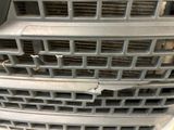 a close up of a car grille with a hole in it
