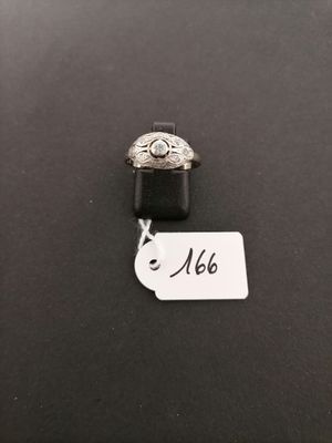 a silver ring with a diamond on it sitting on top of a black surface