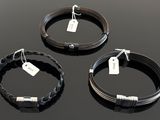 three black wire bracelets with tags on them on a black surface