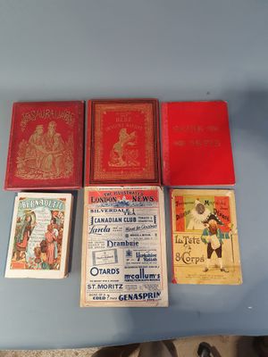 Quatre livres sont posés sur une table recouverte d'une nappe bleue.