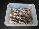 a plastic container filled with silver spoons and spoons