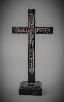 a silver cross with a crucif on a marble base