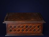 an antique wooden box with a lattice design on the lid