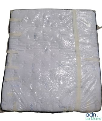 Le matelas est emballé dans du plastique et prêt à être expédié.