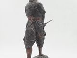 statue of a man with a sword standing on a rock