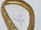 a close up of a gold bracelet on a white surface