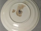 a white plate with a brown stain on it