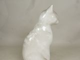 a white cat figurine sitting on a white surface