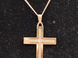 a gold cross on a black surface with a gold chain