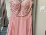 a pink dress hanging on a hanger in a room