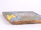 a stone with a design on it sitting on a white surface