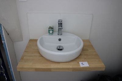 a white sink sitting on a wooden counter in a bathroom