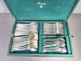a green box with silverware in it on a table